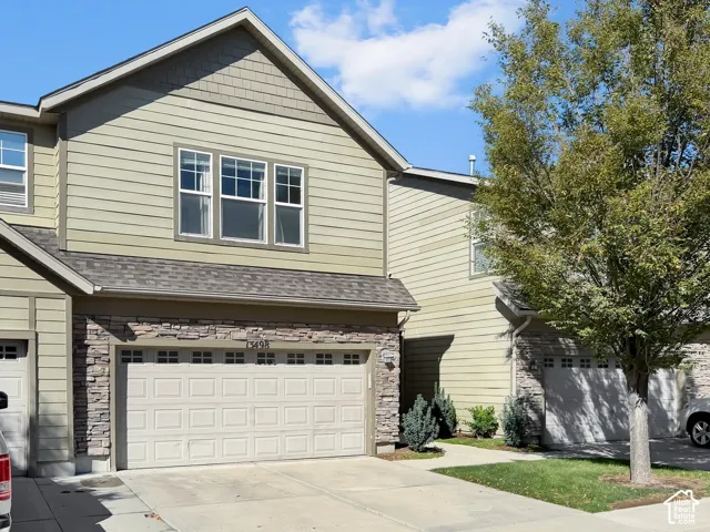 Two-story exterior with light green siding and stone accents