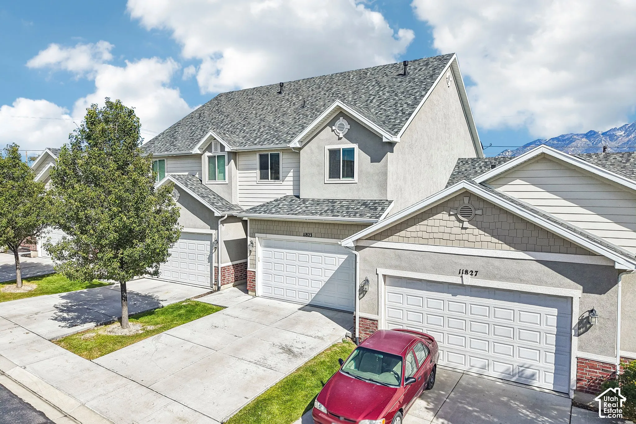 Stucco and siding exterior with brick accents, asphalt shingle roofing, and attached garages