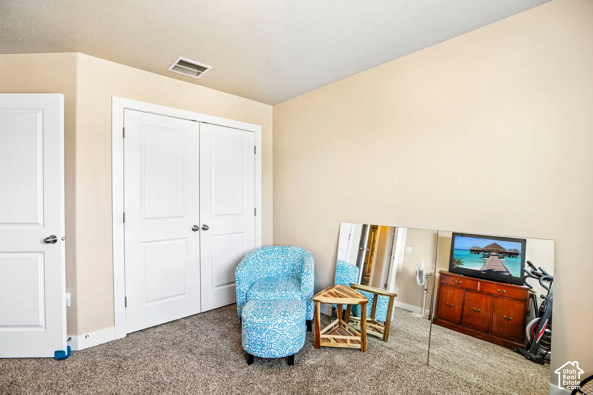Neutral paint tones, textured carpet flooring, white trim, and white paneled doors