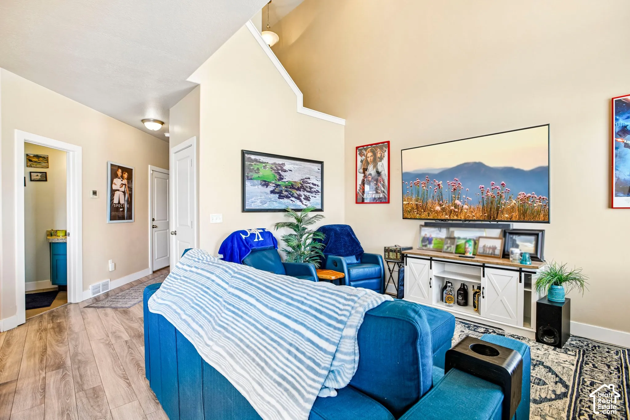 High vaulted ceilings, wood-finish flooring, recessed lighting, white trim, and a built-in media console