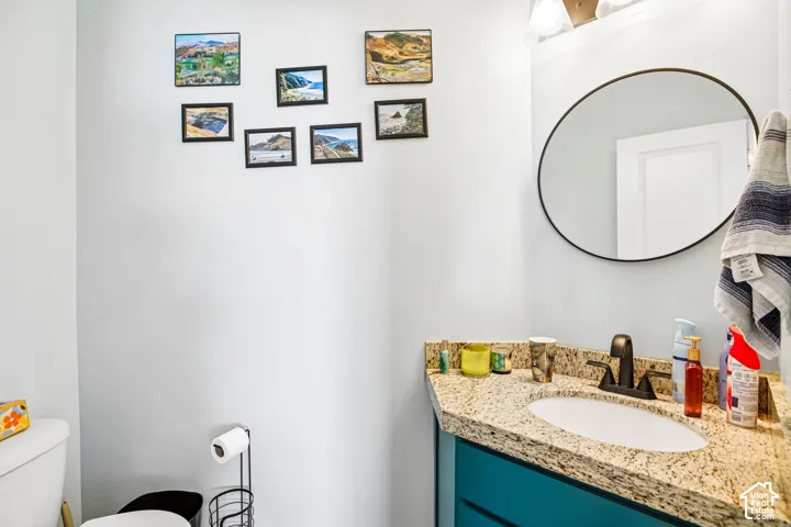 Vanity with a granite-style countertop, undermount sink, and dark bronze faucet