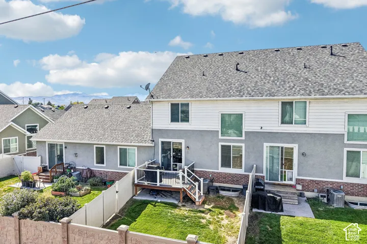 Terraced backyard with a fenced perimeter, featuring a deck and a patio area