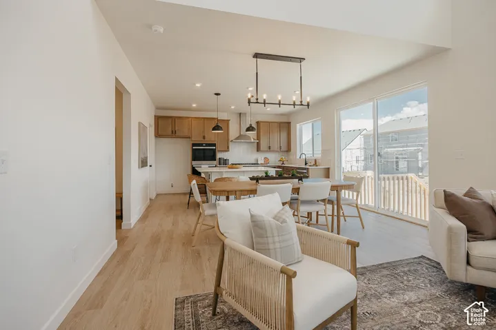 Open-concept living area with wood-finish flooring, a kitchen featuring wood cabinetry, and an island with seating