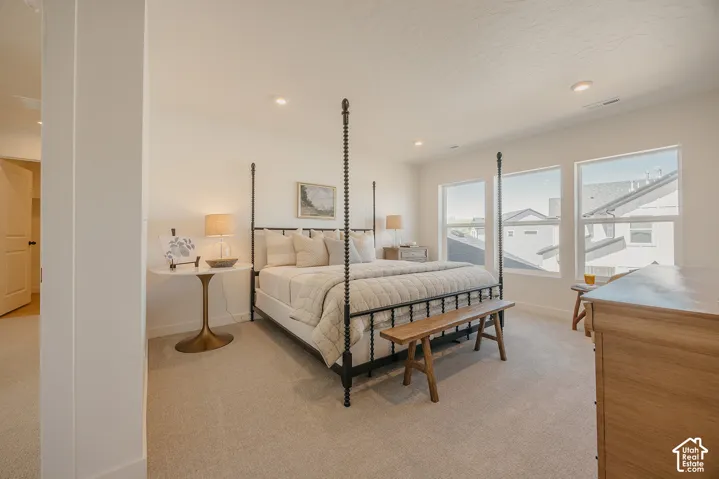 Plush carpet flooring, recessed lighting, and three large windows