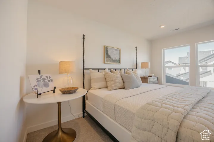 Recessed ceiling lighting, multiple large windows, and wall-to-wall carpeting