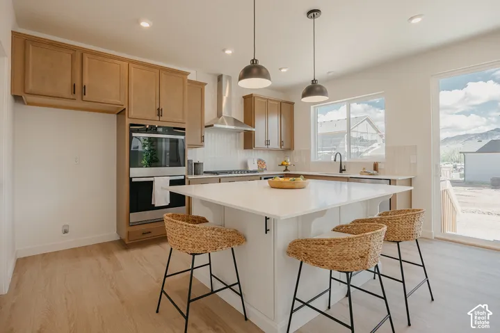 Kitchen featuring light wood-finish flooring, recessed lighting, and a built-in oven