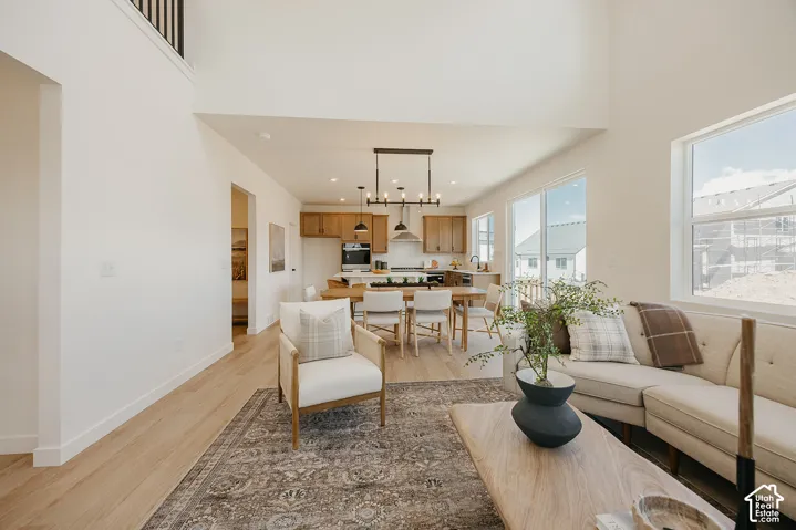 Open concept living space with high ceilings, wood-finish flooring, and multiple windows