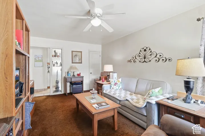 Ceiling fan with integrated lighting, wall-mounted shelving unit, and a doorway opening to a tiled area