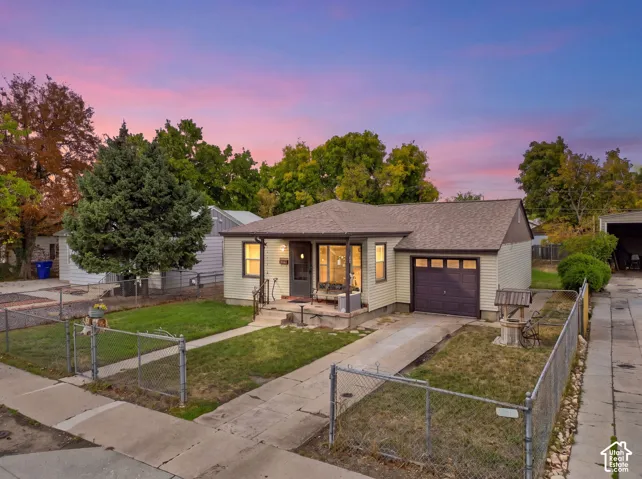 Exterior siding with a gabled roofline, attached garage, concrete driveway, and front lawn