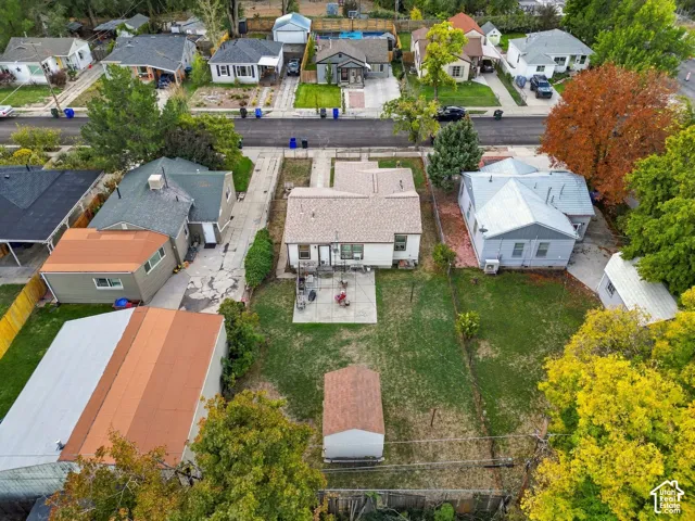 Expansive lot featuring a detached storage shed, a paved patio area, and a mature tree