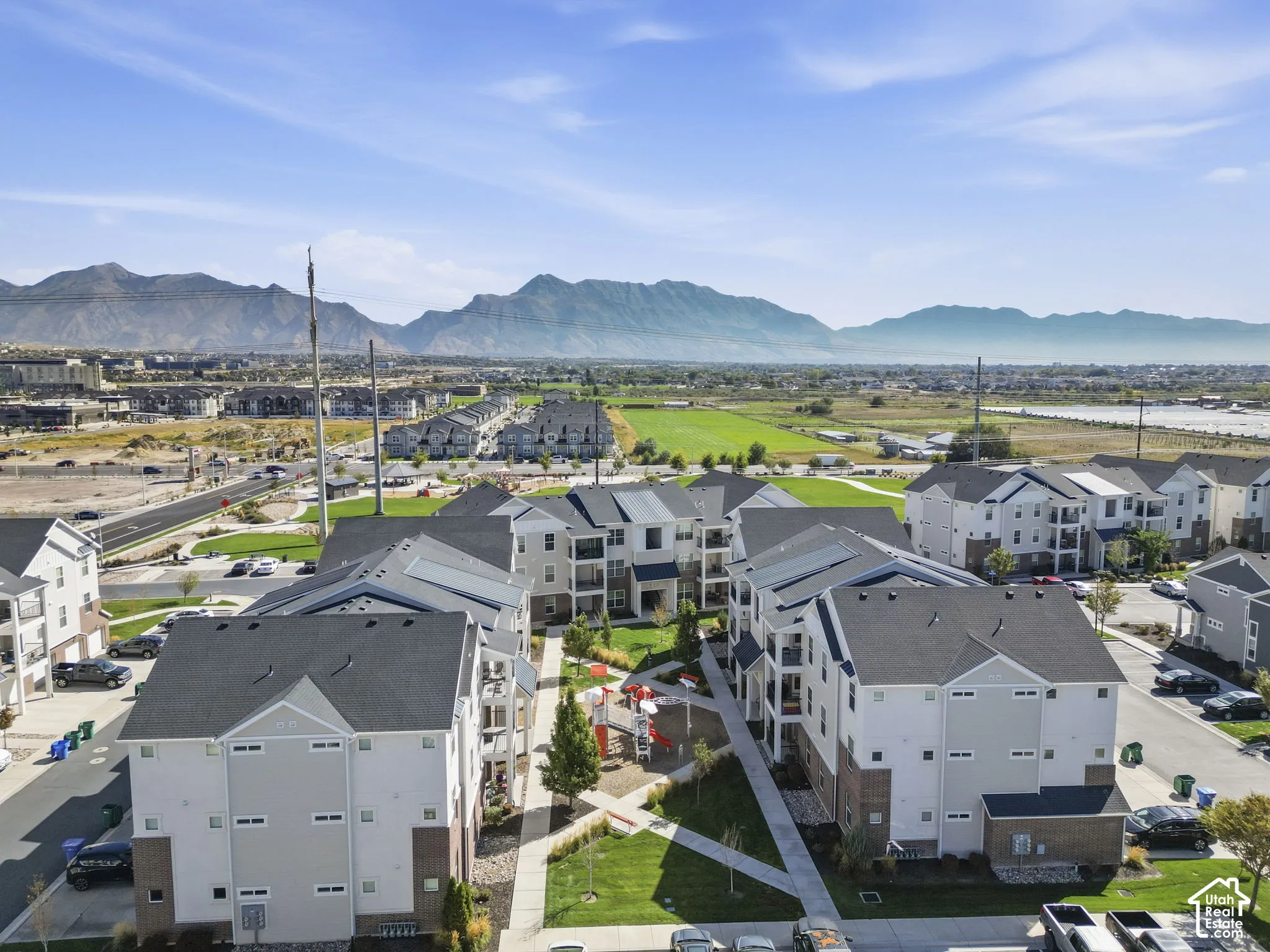 Expansive community featuring multi-story buildings with balconies, paved walkways, and dedicated green spaces