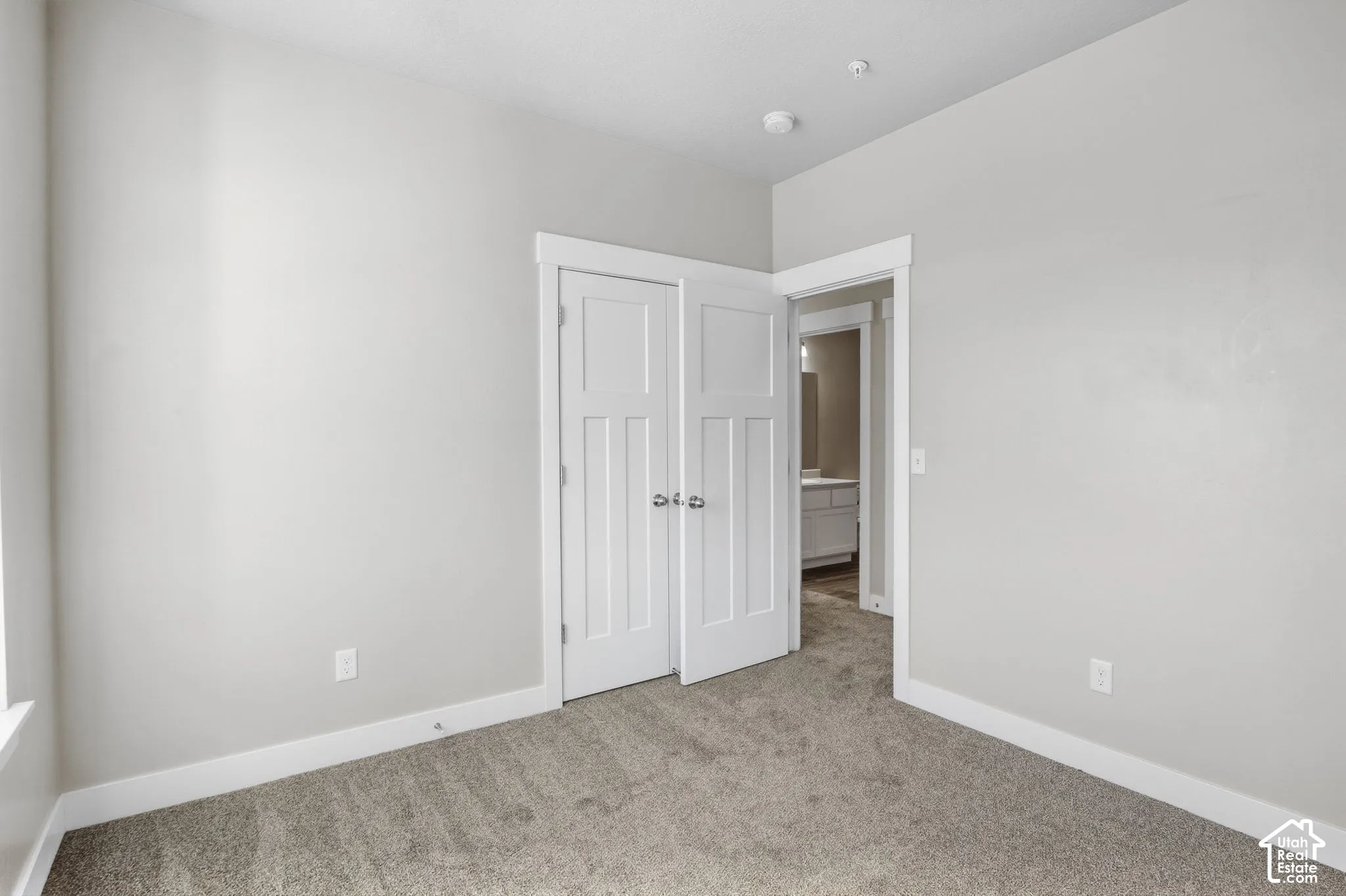 Recessed lighting, light-colored walls, carpeted flooring, and white trim