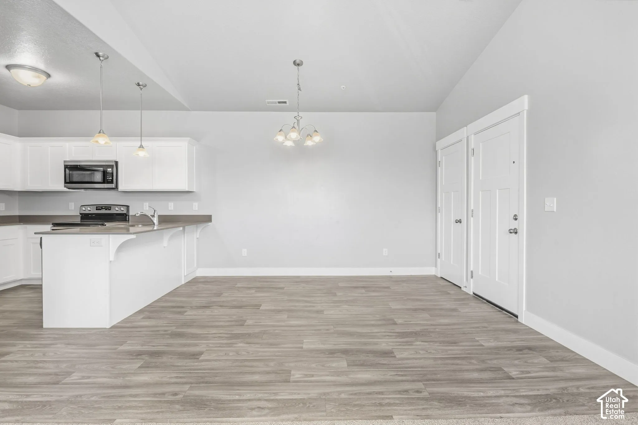Kitchen featuring white cabinetry, a built-in microwave, and a breakfast bar