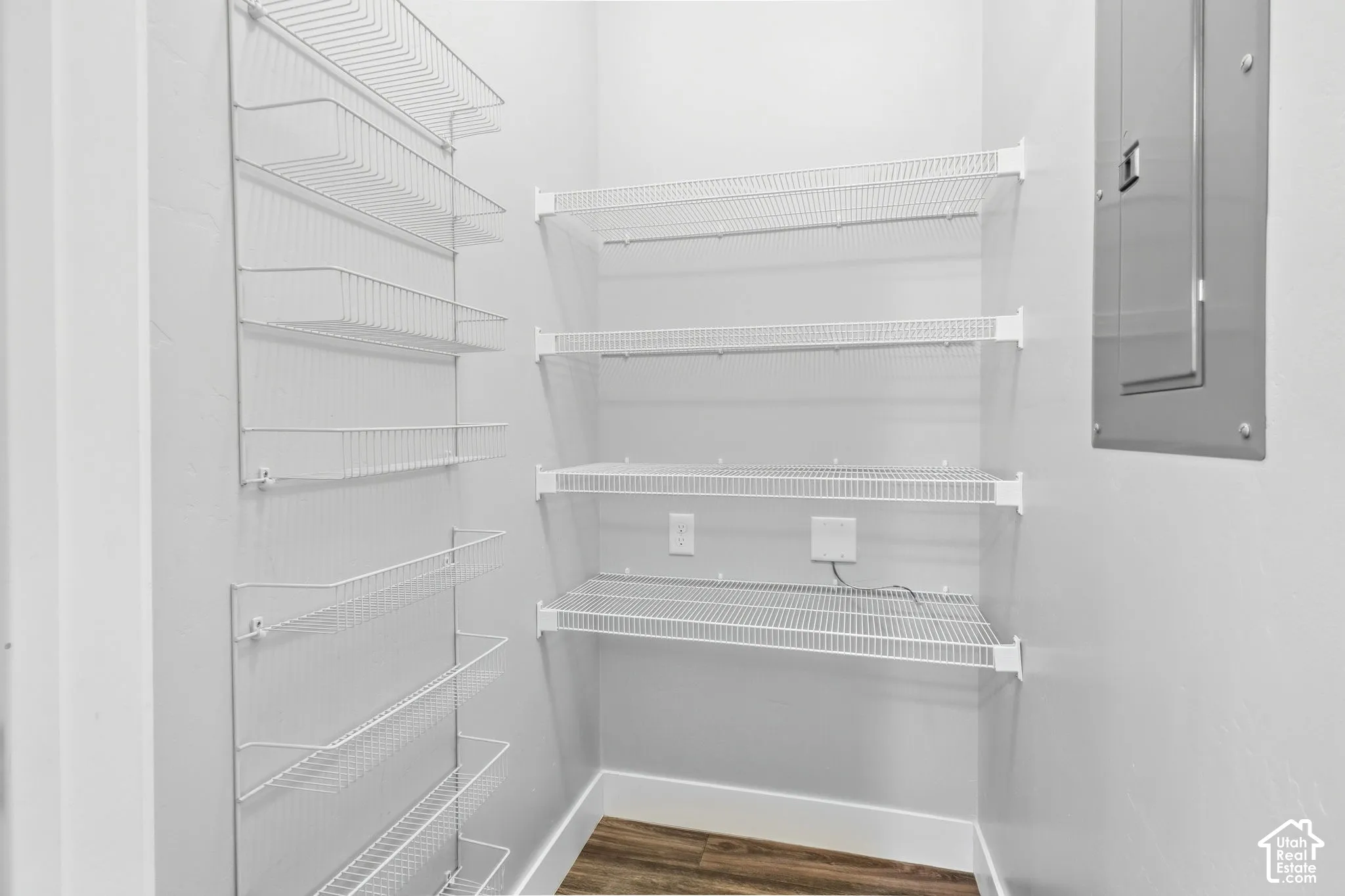 White wire shelving system, wood-finish flooring, and white baseboards