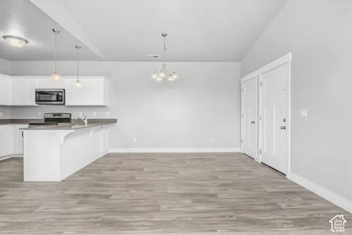 Kitchen featuring white cabinetry, a built-in microwave, and a breakfast bar