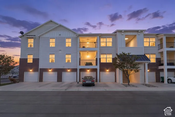 Multi-level building with white siding and brick accents