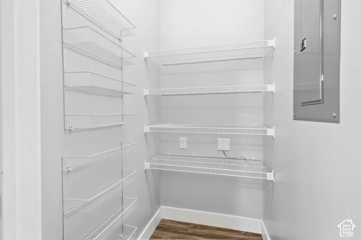 White wire shelving system, wood-finish flooring, and white baseboards