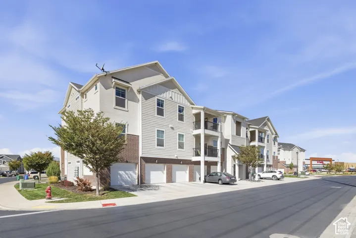 Multi-level exterior with light-toned siding, brick accents, and attached garages