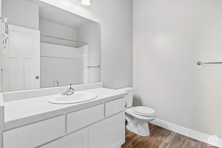 White vanity with integrated sink, chrome faucet, and expansive wall mirror