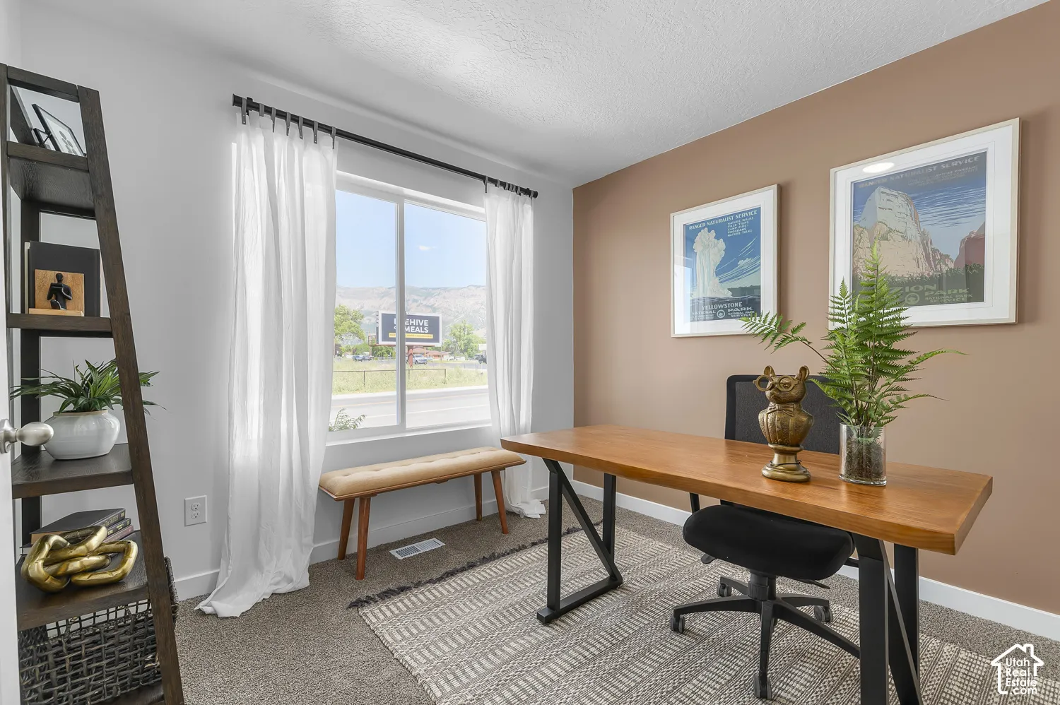 Window with mountain backdrop, neutral wall tones, and carpeted flooring