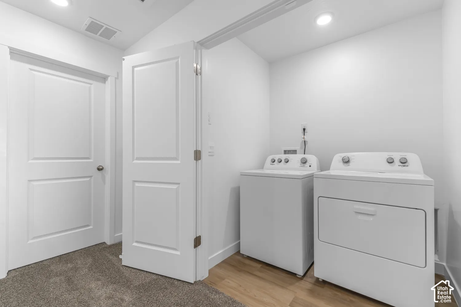 Laundry area with a washer and dryer, wood-finish flooring, and recessed lighting