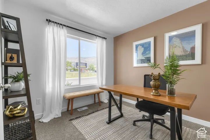 Window with mountain backdrop, neutral wall tones, and carpeted flooring