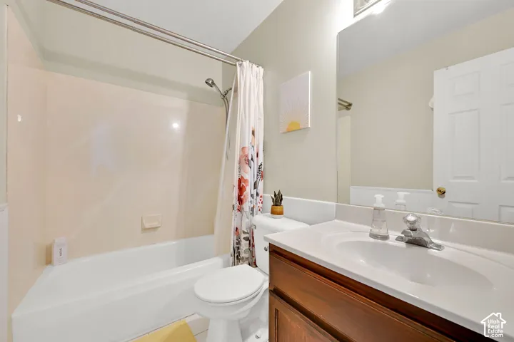 Full bathroom featuring a shower-tub combination, a vanity with a white countertop and integrated sink.  Colors  are tan - NOT pinkish
