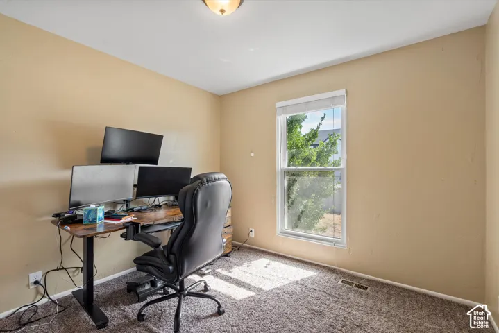 Neutral-toned walls, carpeted flooring, and a single window with blinds