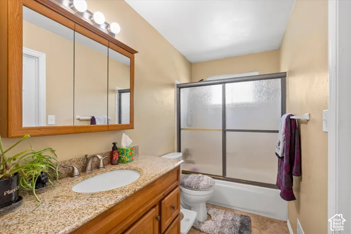 Vanity with a granite-style countertop and an oval undermount sink, complemented by a medicine cabinet with integrated lighting