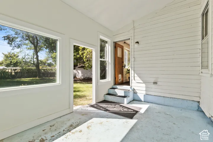 Enclosed back porch & sunroom with large windows & views of backyard
