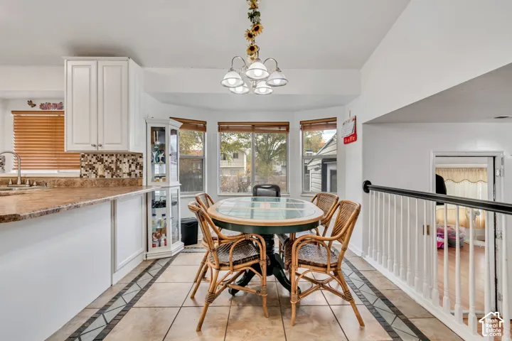 Kitchen with white cabinetry, a tiled backsplash, and a built-in display cabinet