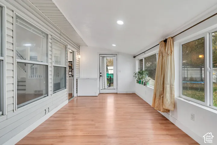 Sunroom with wood-finish flooring, recessed lighting, and multiple large windows