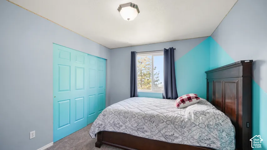 Recessed window, paneled closet doors, textured ceiling, and wall-to-wall carpeting