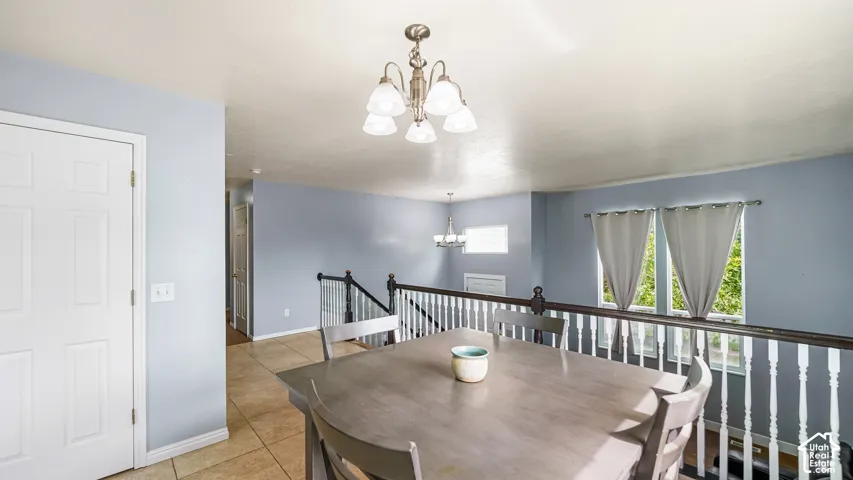 Recessed ceiling, neutral wall paint, tile flooring, and a chandelier with frosted glass shades