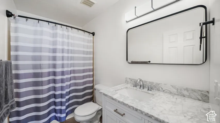 White vanity with chrome hardware, integrated sink, and stone-finish countertop