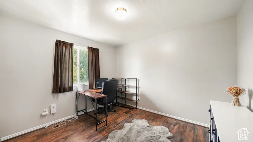 Wood-finish flooring with light-toned walls and a ceiling-mounted light fixture