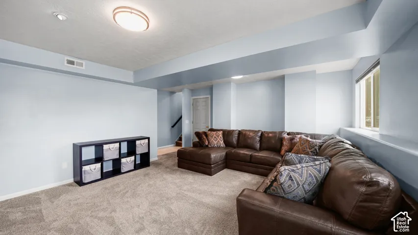 Spacious room featuring light blue walls, gray carpeting, recessed lighting, and a window with a deep sill