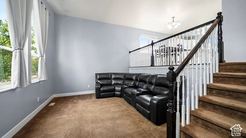 Carpeted flooring with a two-tone staircase featuring white spindles and dark wood banister