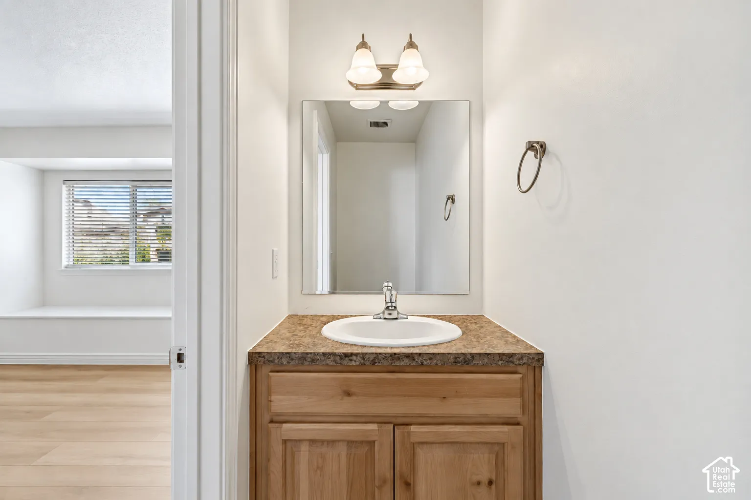 Wood-finish vanity with an integrated sink and laminate countertop