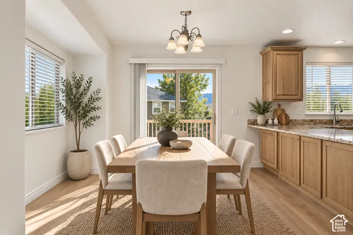 Dining area with wood-finish flooring, a patio door, and a built-in kitchen counter with a sink- VIRTUALLY STAGED