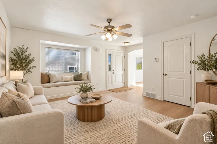 Recessed window bench, wood-finish flooring, ceiling fan with light fixture, arched doorway, and solid panel doors- VIRTUALLY STAGED