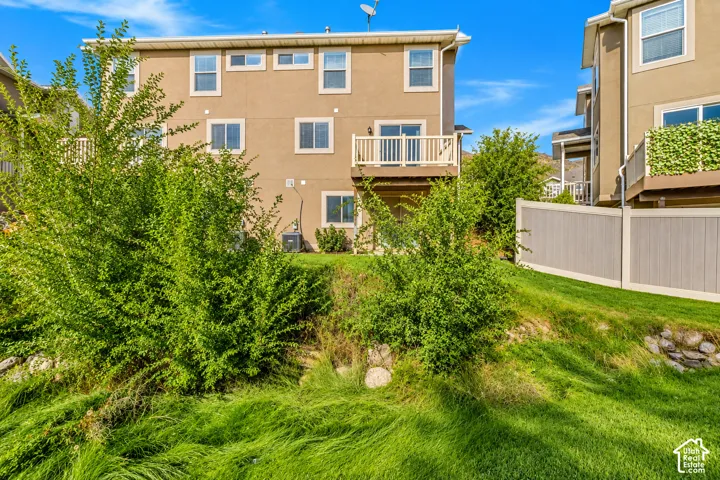 Multi-story stucco exterior featuring multiple windows and a white balustrade deck