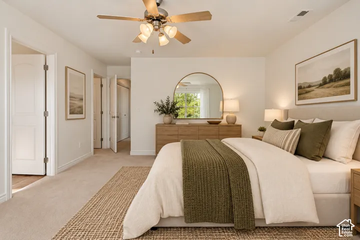 Neutral-toned carpeting, ceiling fan with integrated lighting, multiple paneled doors, and a decorative wall mirror- VIRTUALLY STAGED