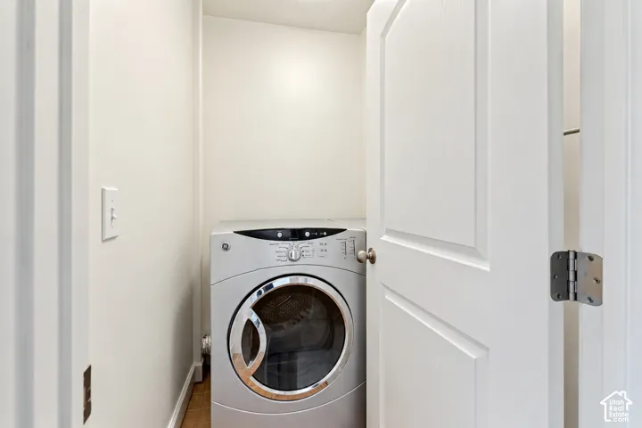 Laundry area featuring a front-loading appliance and a paneled door