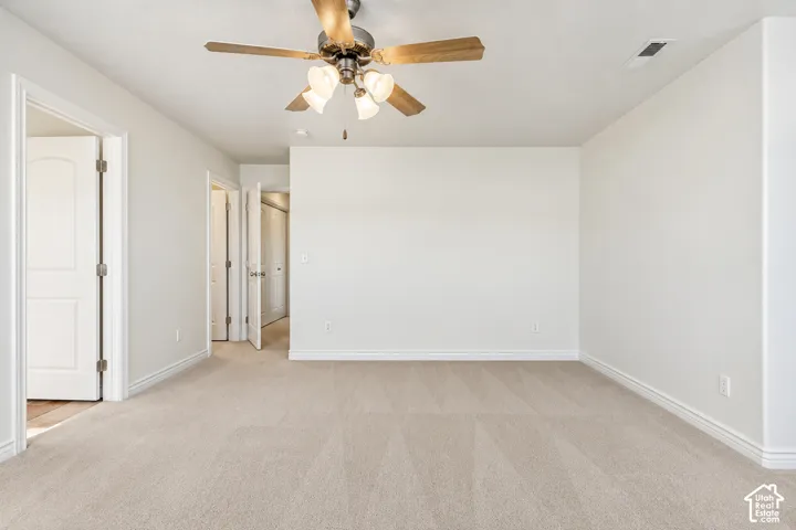 Primary Bedroom Neutral-toned wall paint with light-colored carpeting