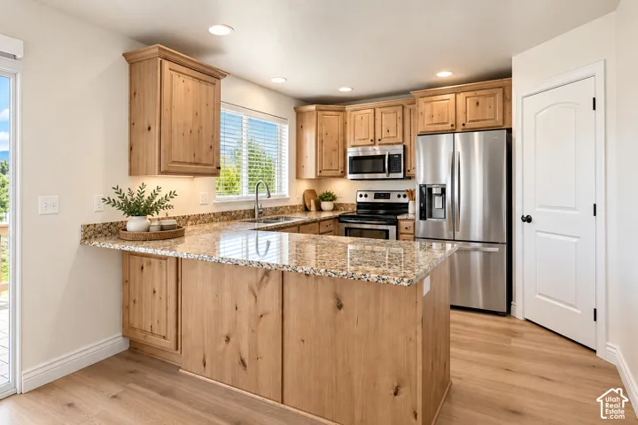 Kitchen with wood cabinetry, light-toned countertops, and stainless steel appliances- VIRTUALLY STAGED