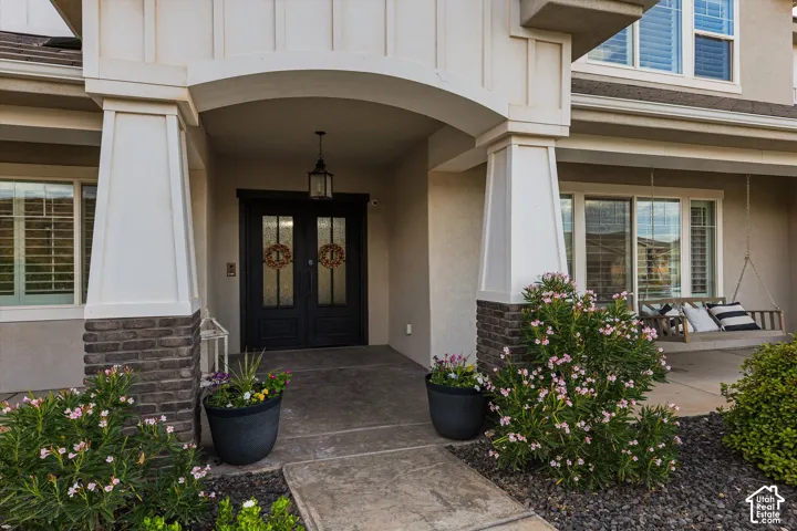 Covered entry with stone-clad columns and a hanging lantern fixture