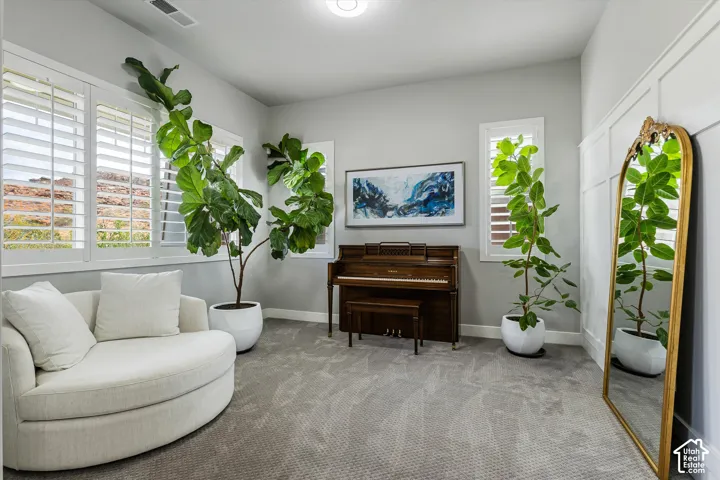 Neutral-toned carpeting, white plantation shutters, and board and batten wall accent