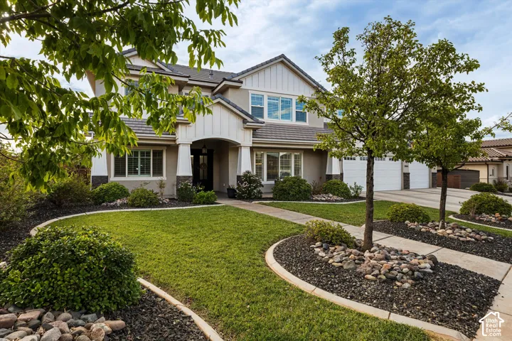 Stucco exterior with stone accents, covered front entry, and a multi-car garage