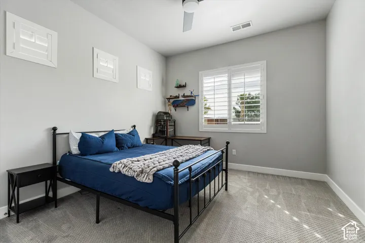 Recessed window with plantation shutters, vaulted ceiling, ceiling fan, and carpet flooring